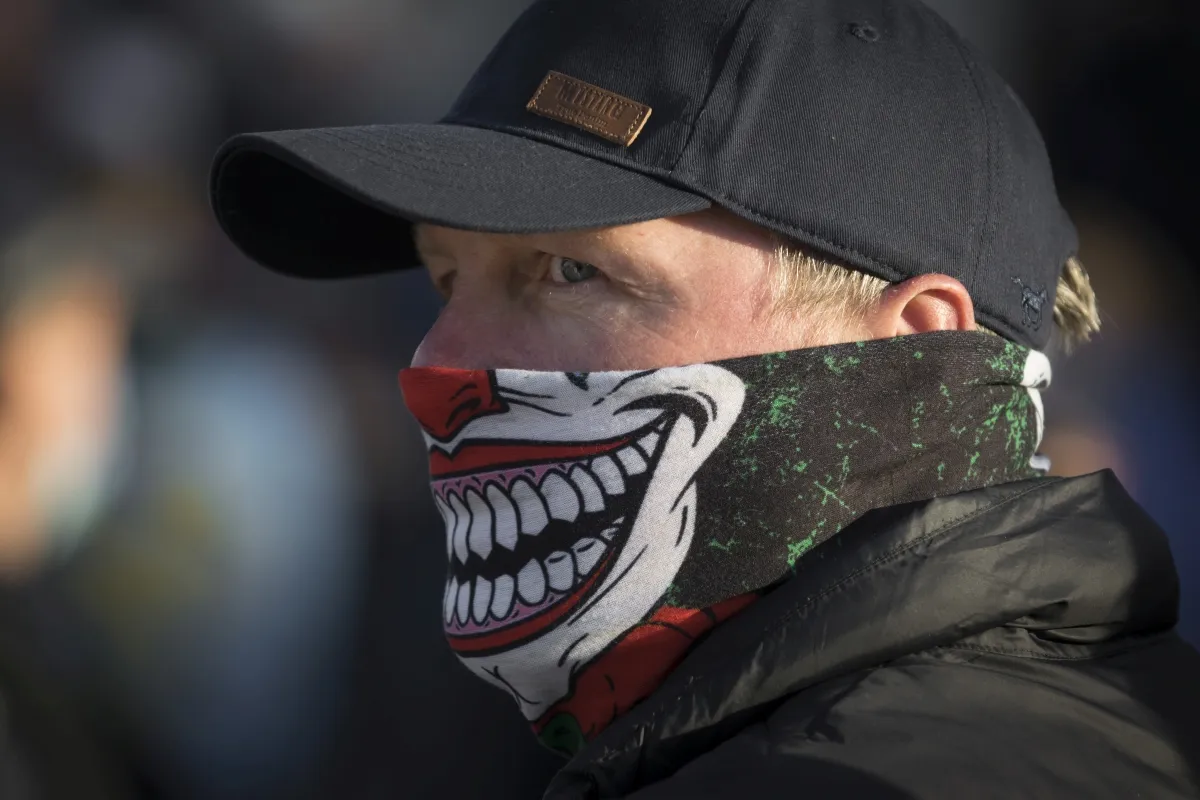 Close-up of a masked man with a grinning face covering